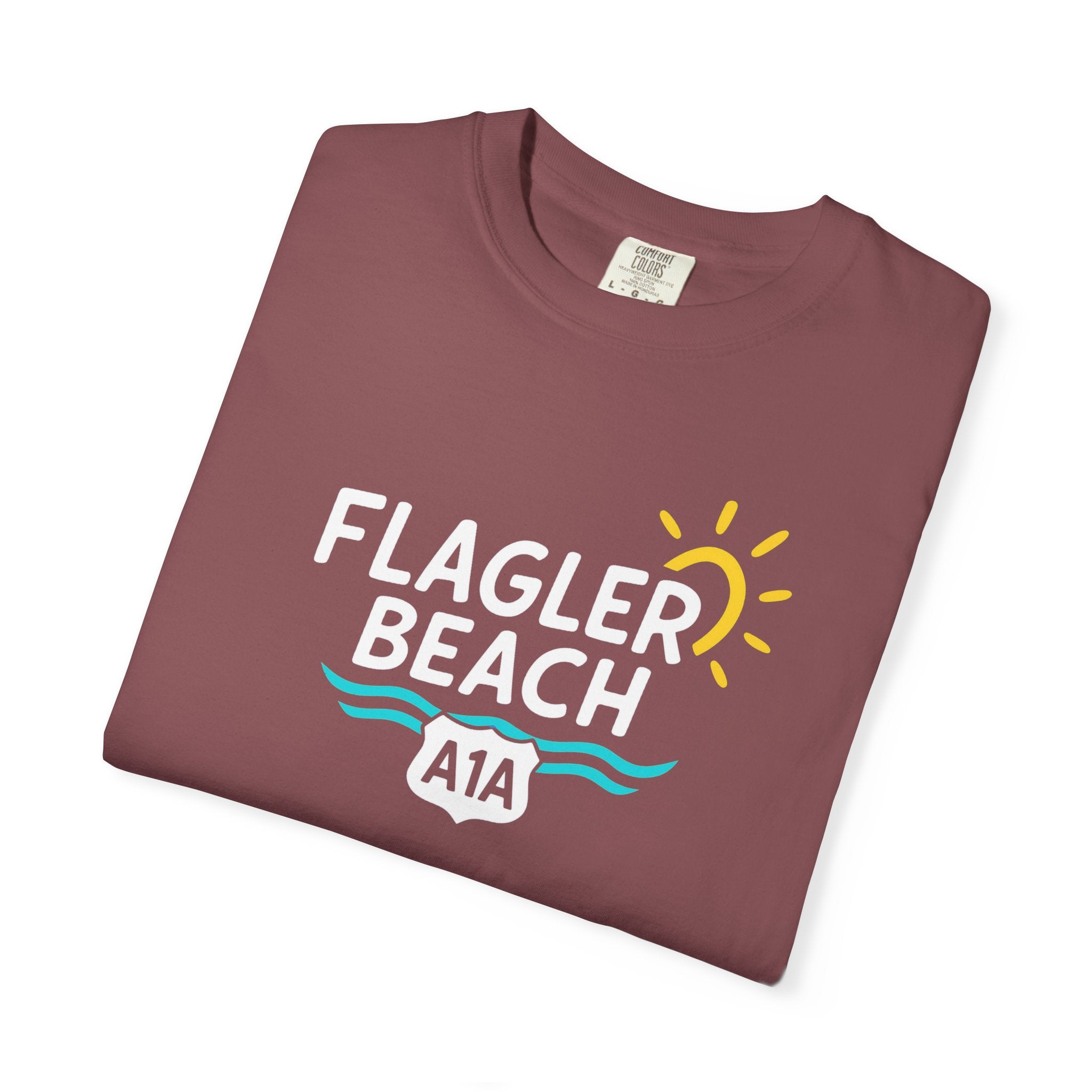 Folded maroon t-shirt with 'Flagler Beach A1A' design on a white background