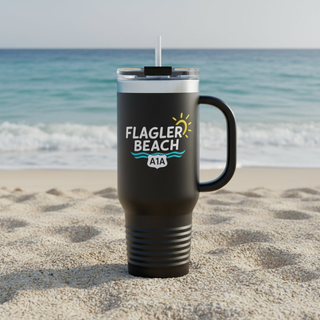 Black travel mug with 'Flagler Beach' text on a sandy beach with ocean in the background