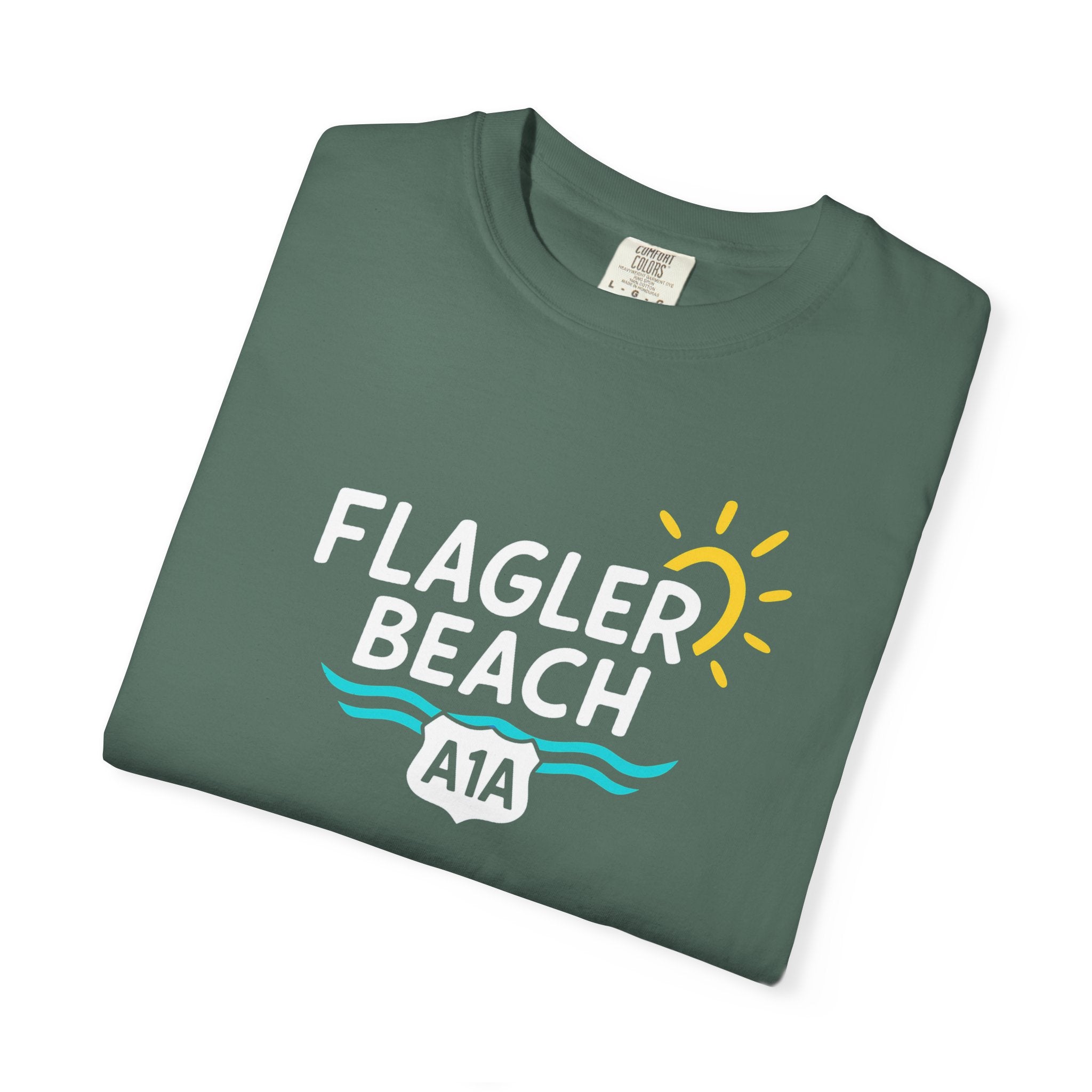 Folded green t-shirt with 'Flagler Beach A1A' text on a white background