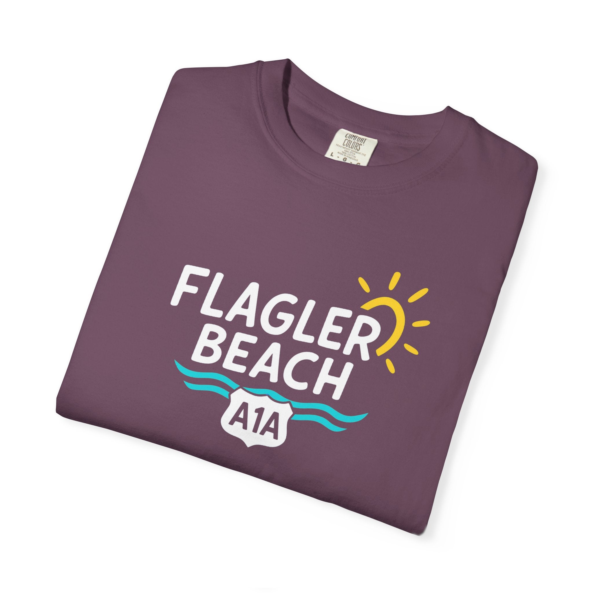 Folded purple t-shirt with 'Flagler Beach A1A' design on a white background